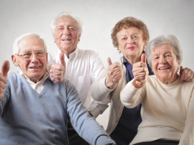 Imagem mostra três idosos fazendo sinal de positivo