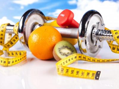 Imagem mostra fita métrica, frutas e peso de musculação 