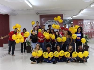 Imagem mostra estudantes com balões amarelos 