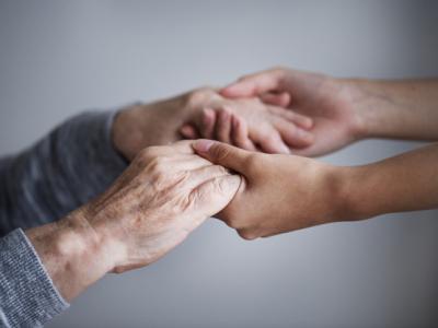 A imagem mostra duas pessoas dando as mãos