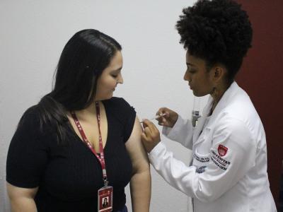 Imagem mostra mulher sendo vacinada