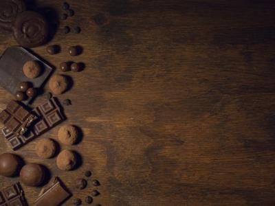 Imagem mostra mesa de madeira com chocolates